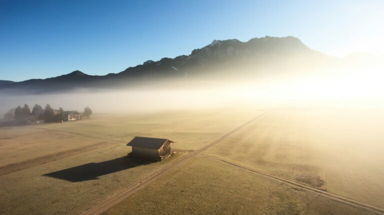 House on agricultural field near hills