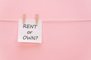 sticker with the inscription RENT or OWN hangs with a clothespin on a rope on a pink background